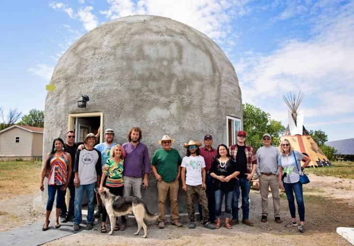 Community members and builders in front of a dome house in Pine Ridge Reservation.