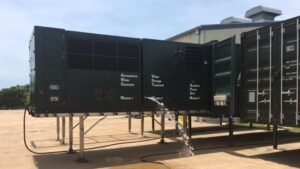 A large-scale AWG system by Moses West, with multiple white water containers ready for community use.